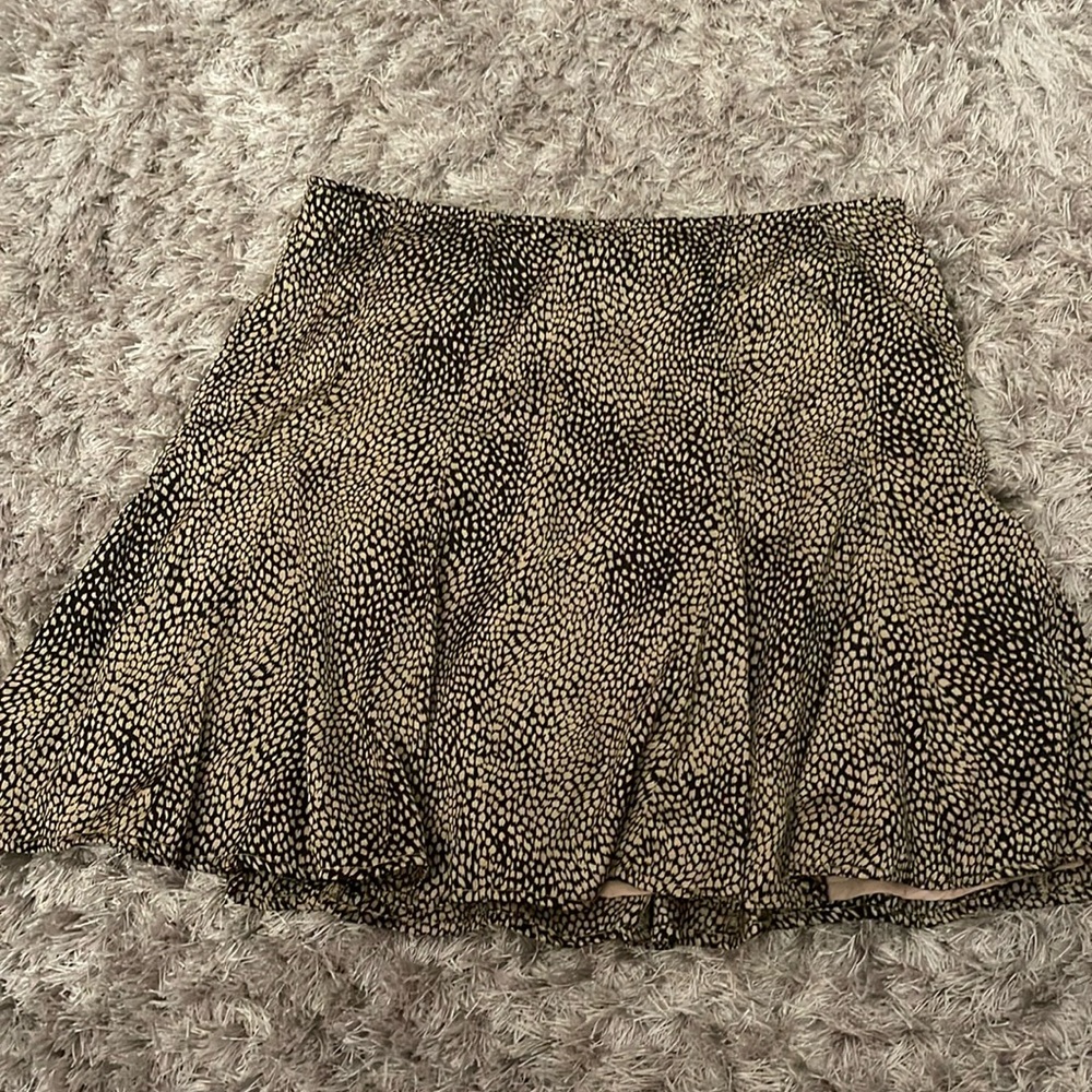Beige and black mini skirt. Tight on waist but flowy.